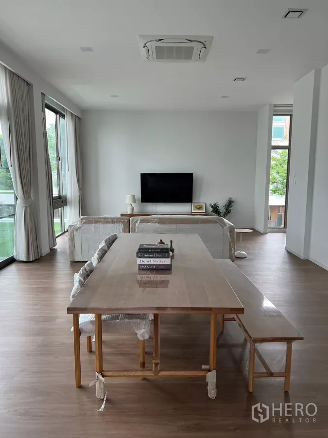 独立式住宅 出租在Saphan Sung, Bangkok - 开放式餐客区，长餐桌、吊顶空调与电视墙。