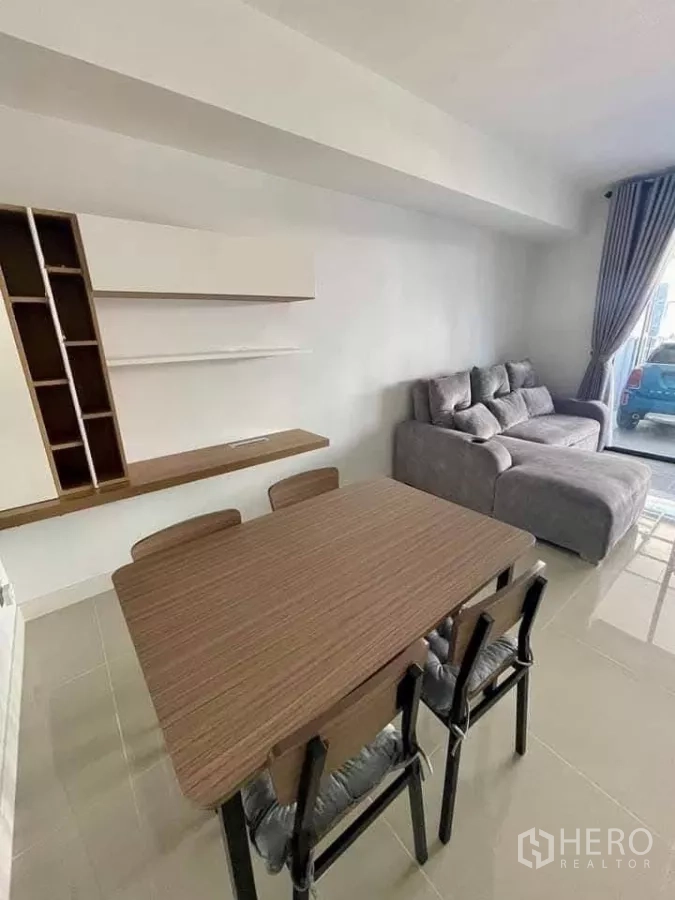 Townhouse for rent in Bang Phli, Samut Prakan - Dining area beside the living room with four-seat wooden table and wall shelves.