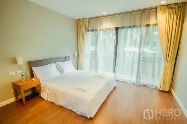 บ้าน ให้เช่าในKhlong Toei, Bangkok - ห้องนอนโปร่งสว่าง เตียงนอน หน้าต่างสูงจรดเพดาน ผ้าม่านโปร่ง และระเบียง.