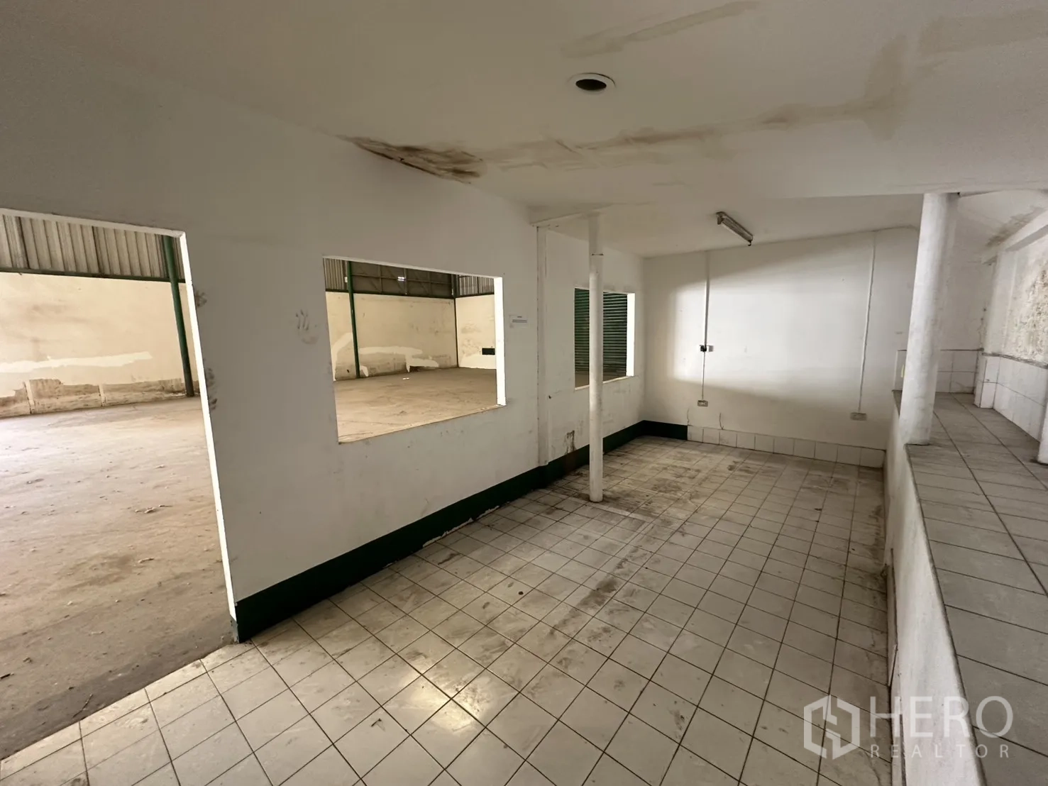 Warehouse for rent in Suan Luang, Bangkok - Tiled office or staff room with service counter and interior windows overlooking the warehouse.