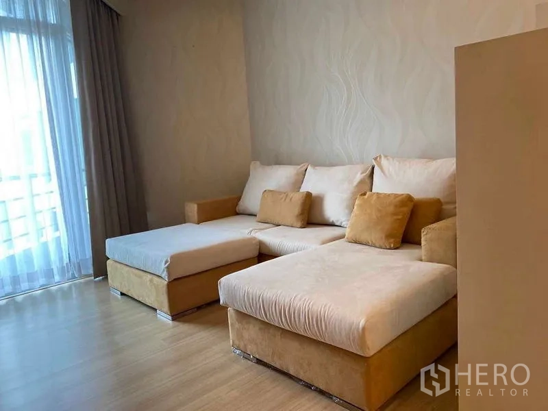 คอนโด ให้เช่าในKhlong San, Bangkok - ห้องนั่งเล่นพร้อมโซฟาตัวแอลข้างหน้าต่างบานสูงและม่านโปร่ง