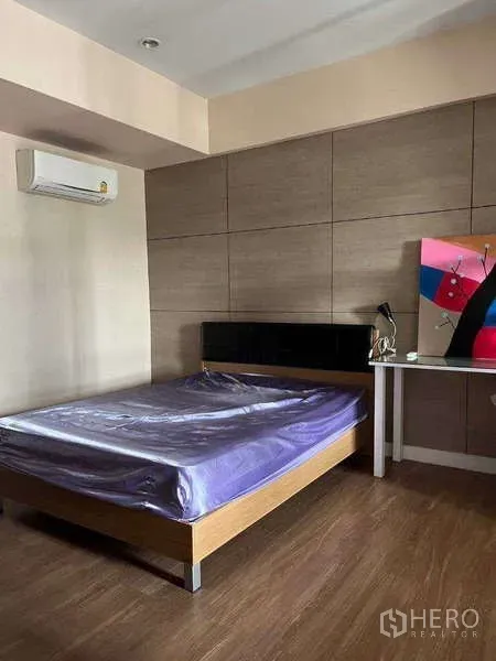 ทาวน์เฮาส์ ให้เช่าในKhlong Toei, Bangkok - ห้องนอนพื้นไม้ ผนังลายไม้พร้อมเครื่องปรับอากาศและเตียงข้างโต๊ะทำงาน