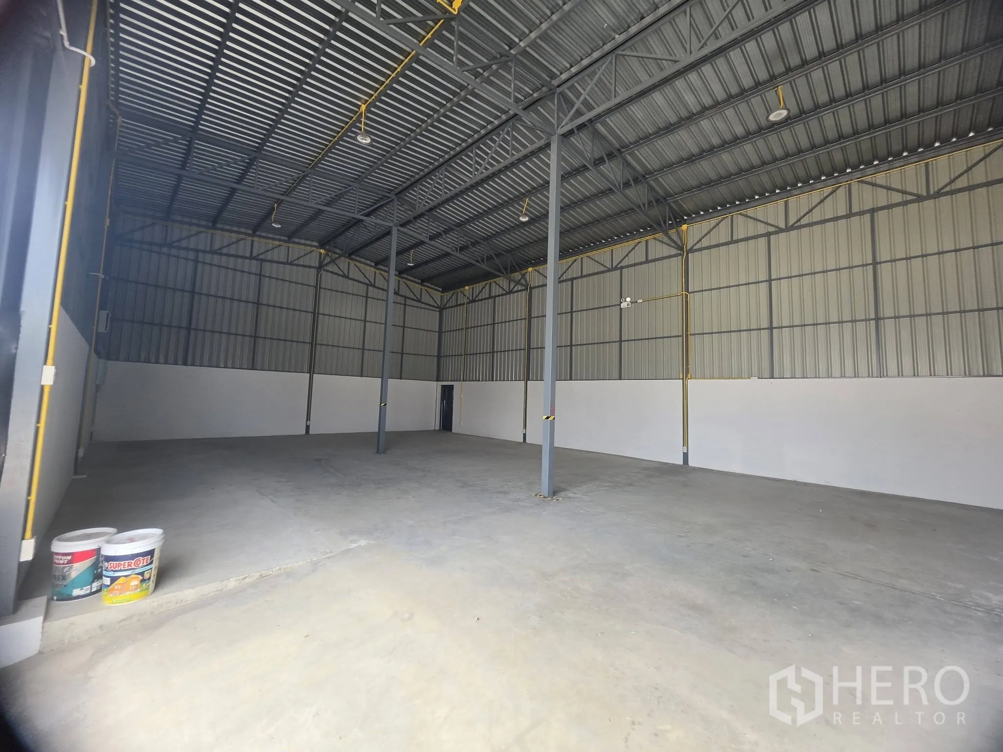 โกดัง for rent in Mueang Samut Prakan, Samut Prakan - มุมมองจากทางเข้าเห็นพื้นที่โล่ง เสาค้ำ และประตูทางออกด้านหลัง