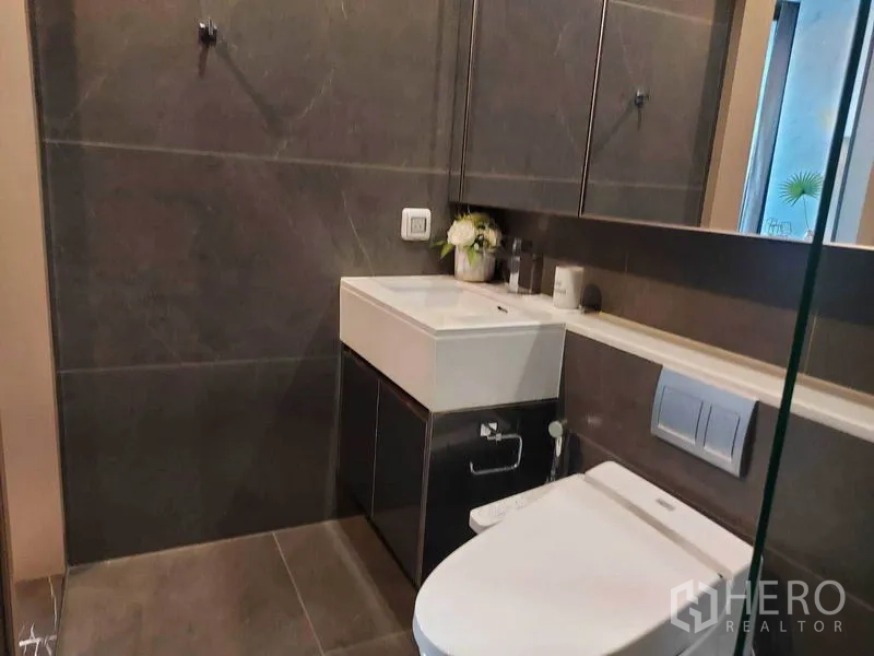 คอนโด ให้เช่าในHuai Khwang, Bangkok - ห้องน้ำโมเดิร์นผนังหินสีเข้ม อ่างล้างหน้า และโถสุขภัณฑ์แขวนผนัง