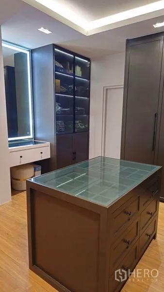 独立式住宅 出售在Sai Mai, Bangkok - 主卧步入式衣帽间，带玻璃台岛与照明柜。