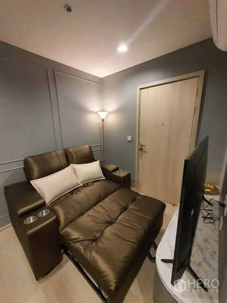 Condominium for rent - Recliner sofa extended into a daybed in the living room facing the TV.