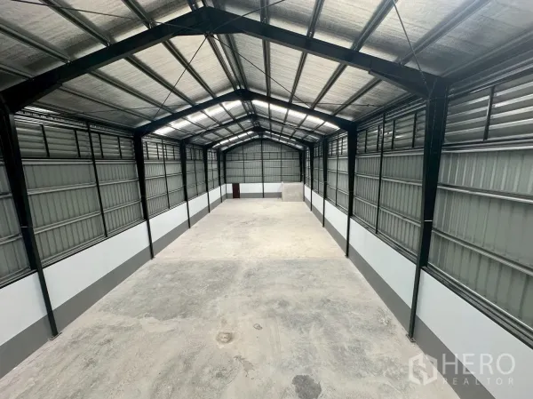 Warehouse for rent in Suan Luang, Bangkok - Spacious warehouse interior with steel frame roof, insulation panels and open loading area.
