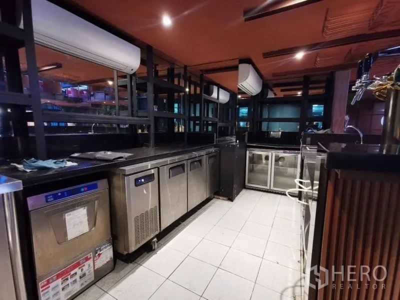 พื้นที่ขายปลีก ให้เช่า - โซนหลังบาร์พร้อมตู้แช่ เครื่องล้างจาน และท็อปหินสีดำ