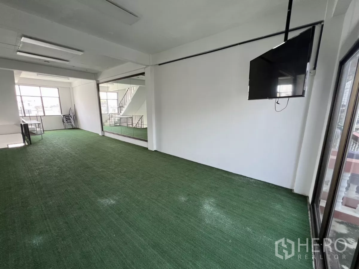 店屋 出租在Watthana, Bangkok - 工作室另一角，落地镜与壁挂电视、阳台推拉门。