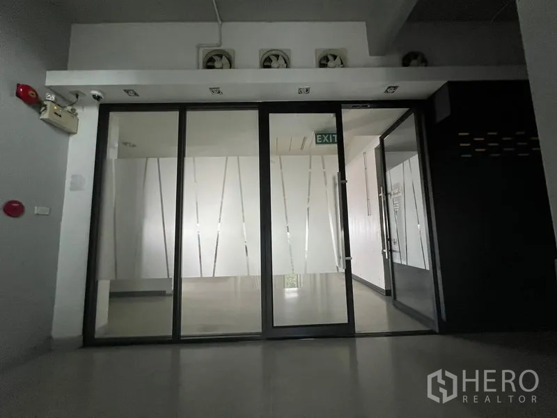 Office Space for rent in Mueang Samut Prakan, Samut Prakan - Main entrance featuring frosted glass sliding doors and exit sign.