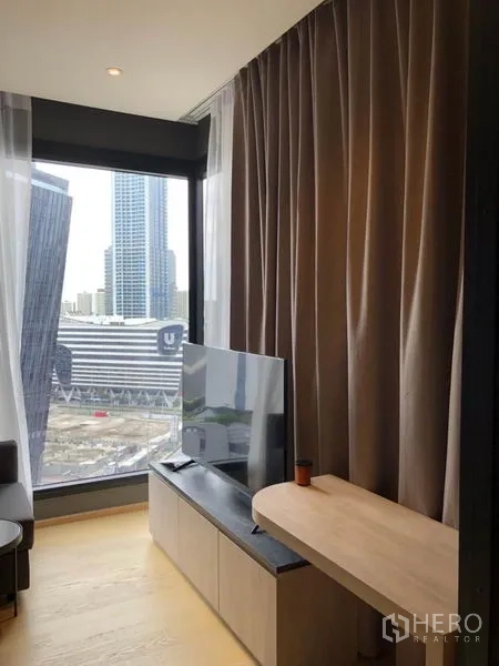 คอนโด ให้เช่าในDin Daeng, Bangkok - มุมห้องนั่งเล่นหน้าต่างใหญ่ ตู้วางทีวี และวิวสกายไลน์เมือง