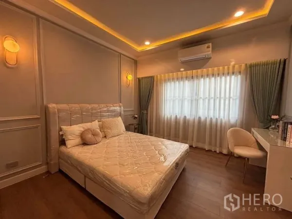 Detached House for rent in Bang Phli, Samut Prakan - Cozy bedroom with cove lighting, large window with sheer curtains, desk and upholstered chair.