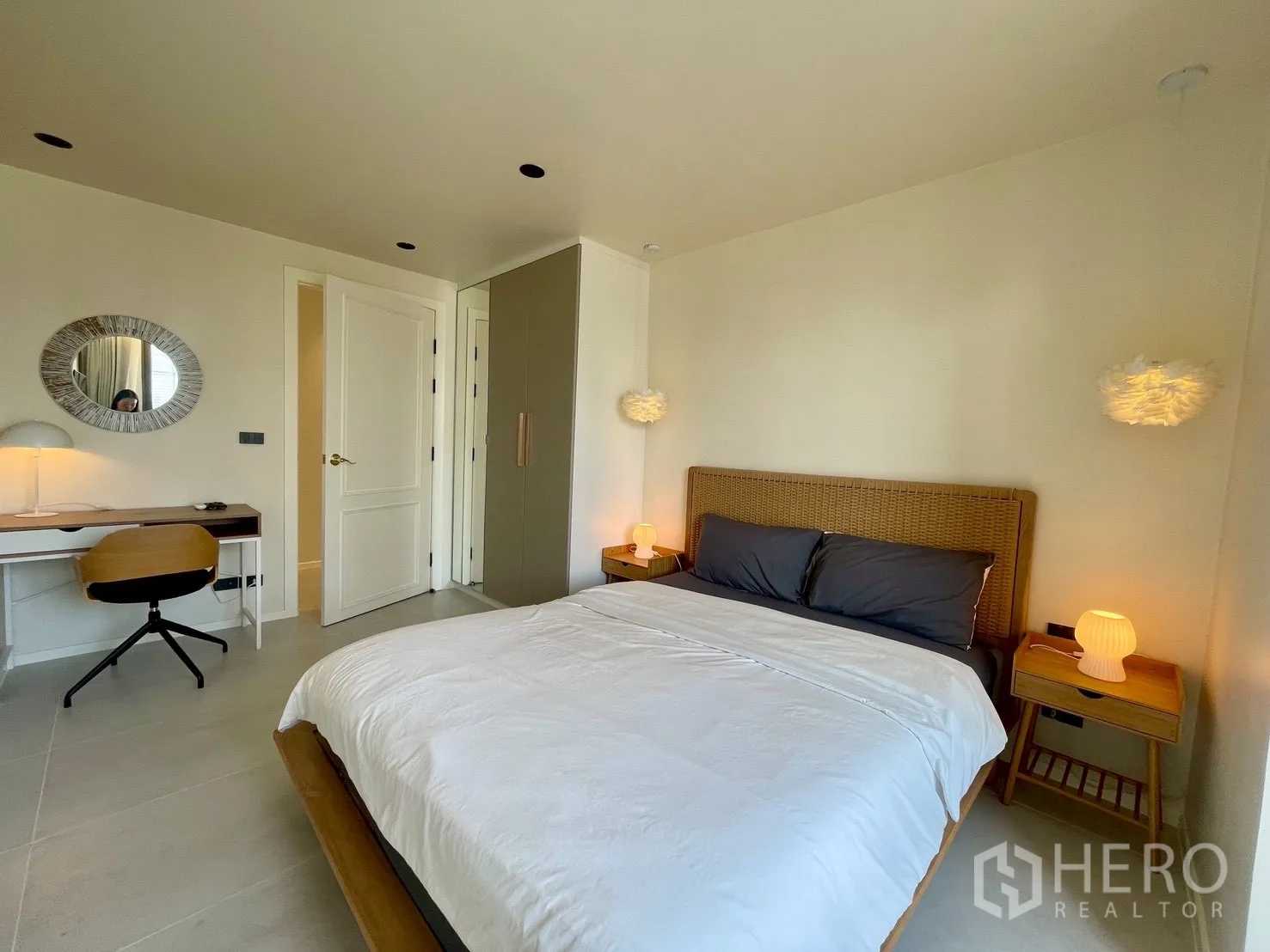 Condominium for sale in Watthana, Bangkok - Cozy bedroom with work desk, wardrobe, and soft pendant lights.