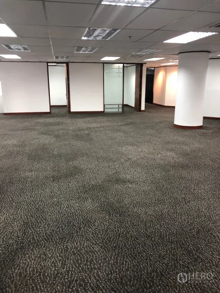 Office Space for rent in Khlong Toei, Bangkok - Large workspace featuring grid ceiling, fluorescent lighting and glass-door meeting rooms.