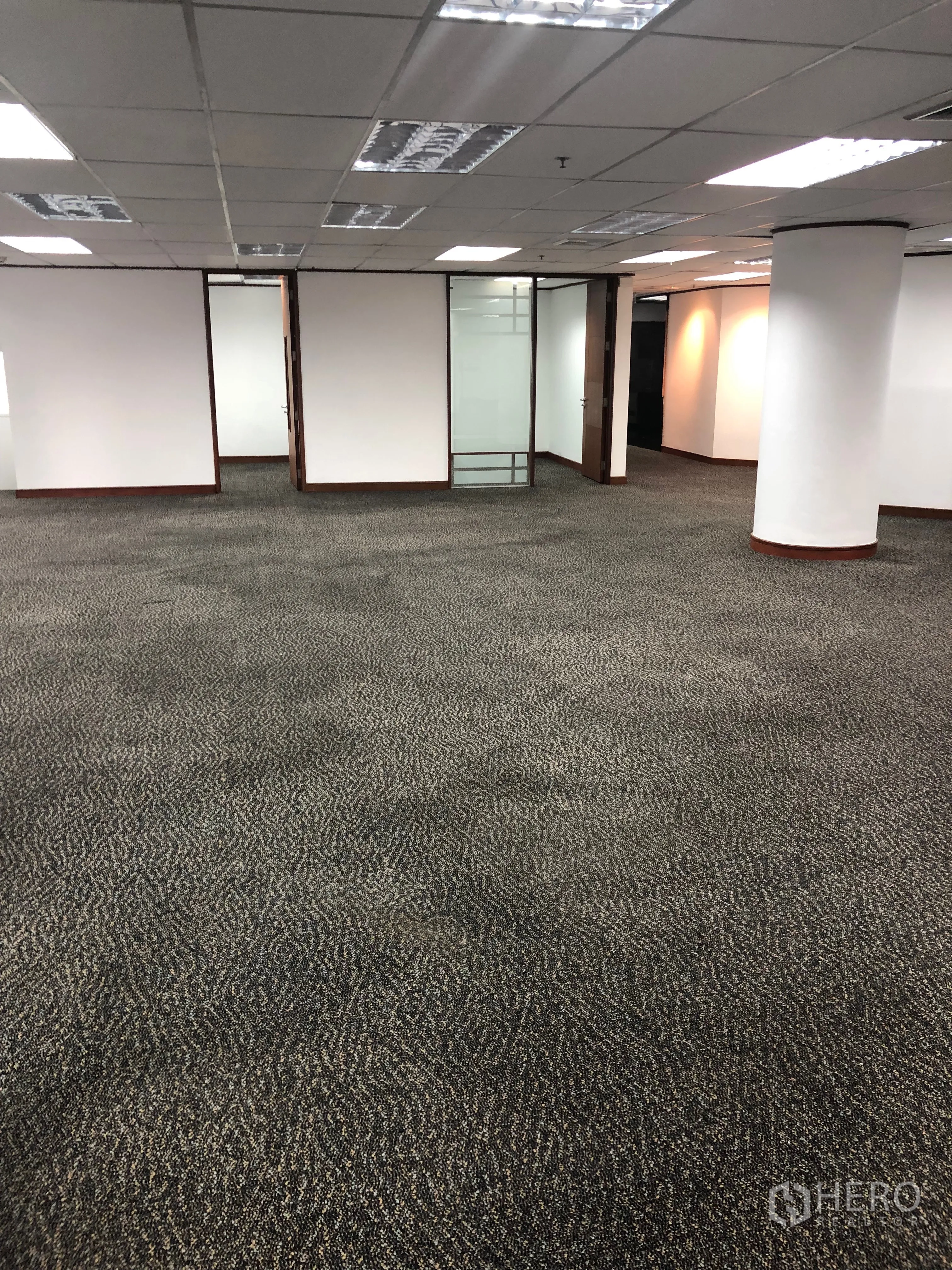 Office Space for rent in Khlong Toei, Bangkok - Large workspace featuring grid ceiling, fluorescent lighting and glass-door meeting rooms.