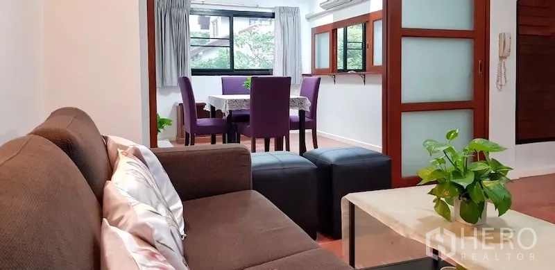 独立式住宅 出租在Chatuchak, Bangkok - 温馨起居区连接餐区，推拉窗与花园景观。