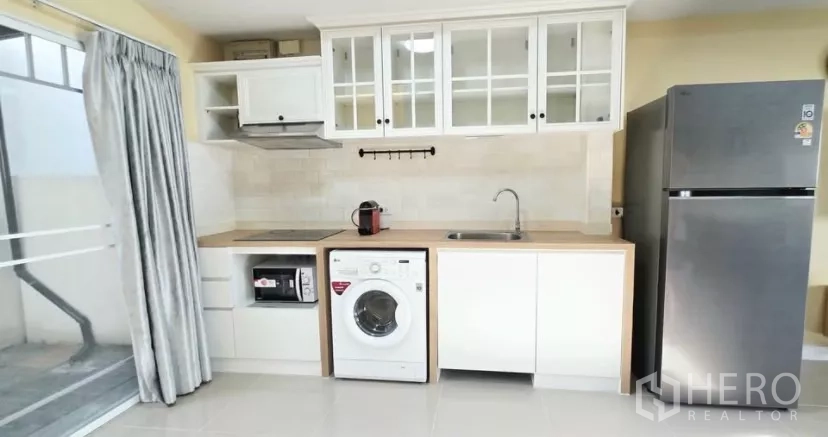 Townhouse for rent in Bang Bo, Samut Prakan - Straight-on view of kitchen cabinetry, sink and built-in appliances.