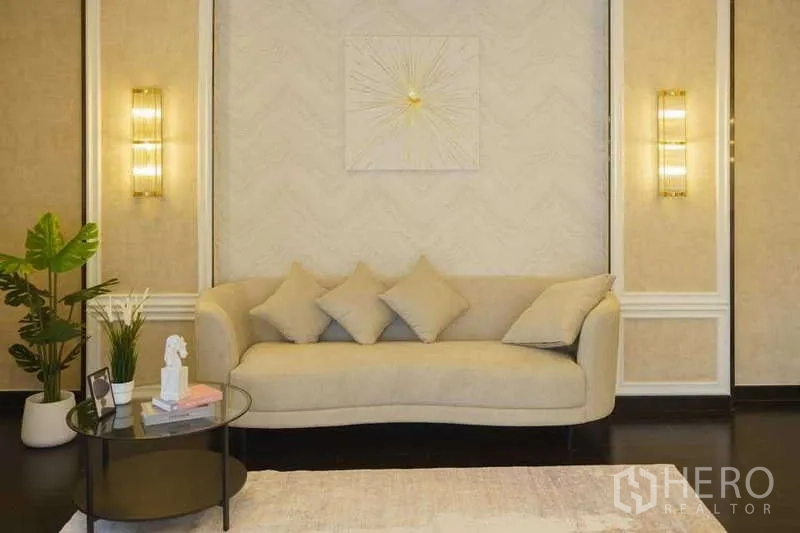 Detached House for rent or sale in Bang Phli, Samut Prakan - Cozy sitting nook with curved sofa, wall sconces and side table.