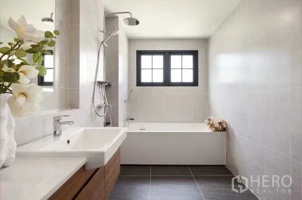 Detached House for sale in Bang Phli, Samut Prakan - Modern bathroom with bathtub, rain shower, tiled walls and a window for natural light.