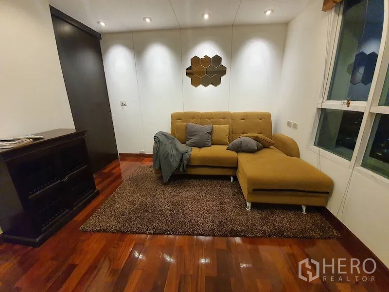 Condominium for rent or sale in Pathum Wan, Bangkok - Cozy second living area or study with mustard L-shaped sofa, rug and windows.