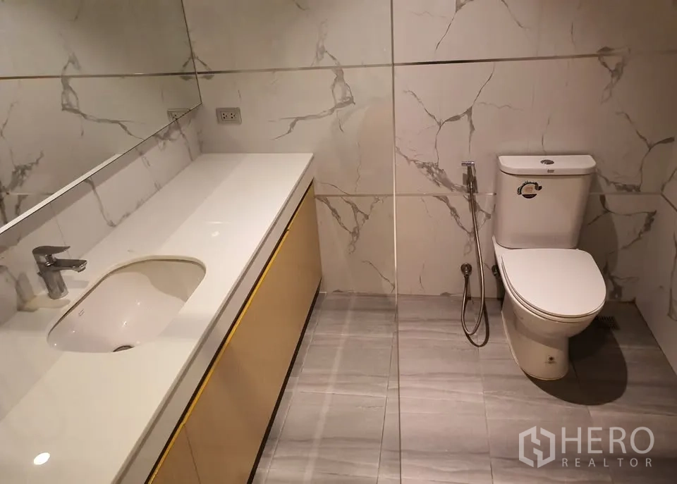 คอนโด for rent in Watthana, Bangkok - ห้องน้ำแขกพร้อมเคาน์เตอร์ยาว โถสุขภัณฑ์ และผนังลายหินอ่อน