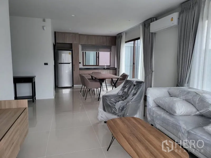 Detached House for rent in Bang Kapi, Bangkok - Open lounge and dining space with built-in cabinetry, fridge and wide windows.