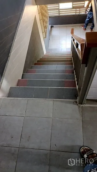 Retail Space for sale in Lam Luk Ka, Pathum Thani - View down a tiled staircase with metal handrail and side window.