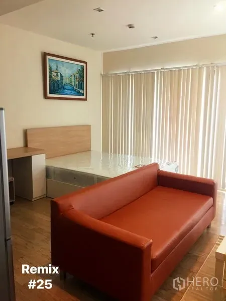 คอนโด ให้เช่าในKhlong Toei, Bangkok - พื้นที่นั่งเล่นแบบสตูดิโอ มีโซฟาสีส้ม เตียง ผ้าม่านบังแสงสูงจรดเพดาน และภาพตกแต่งผนัง