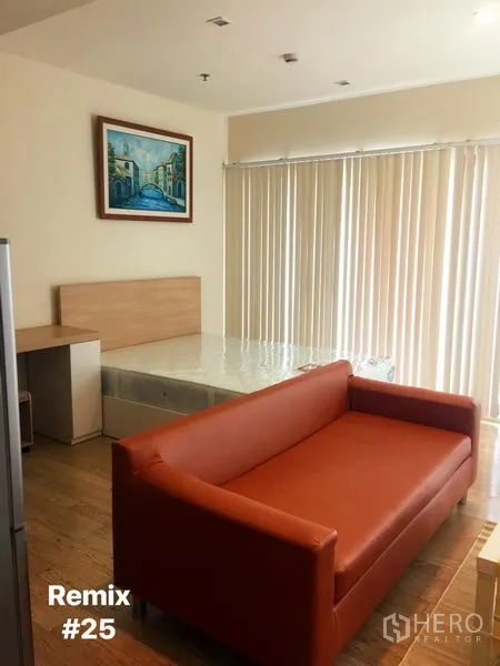 คอนโด ให้เช่าในKhlong Toei, Bangkok - พื้นที่นั่งเล่นแบบสตูดิโอ มีโซฟาสีส้ม เตียง ผ้าม่านบังแสงสูงจรดเพดาน และภาพตกแต่งผนัง