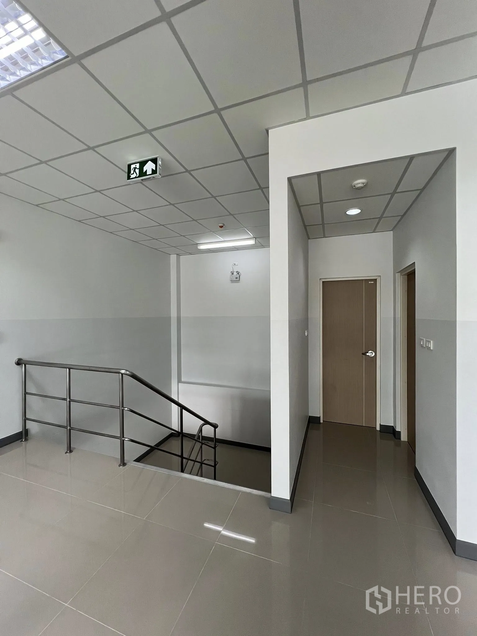 Warehouse for rent in Phra Pradaeng, Samut Prakan - Upper landing with stair access and a doorway to a separate room.