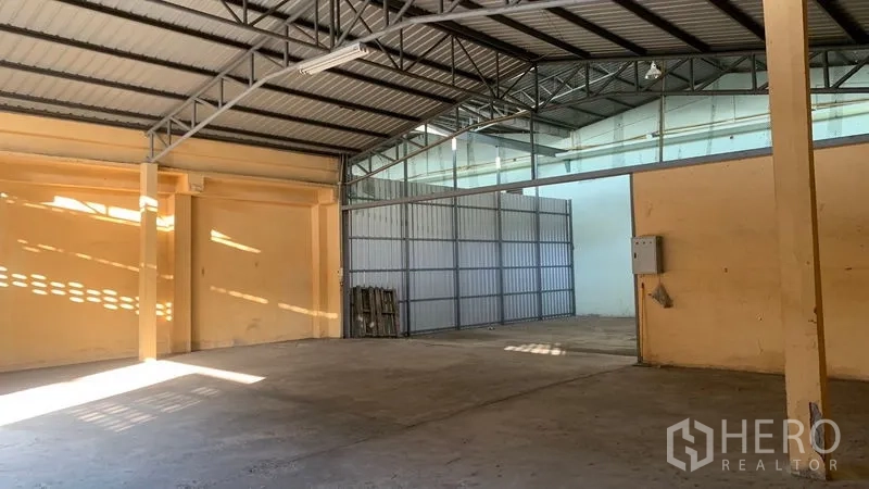 Warehouse for rent in Mueang Nakhon Pathom, Nakhon Pathom - Open storage bay under steel truss roof with clerestory windows and painted walls.