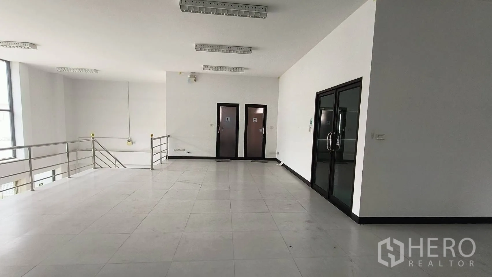 Office Space for rent in Khlong Toei, Bangkok - Mezzanine landing with twin restroom doors and glass office entry.