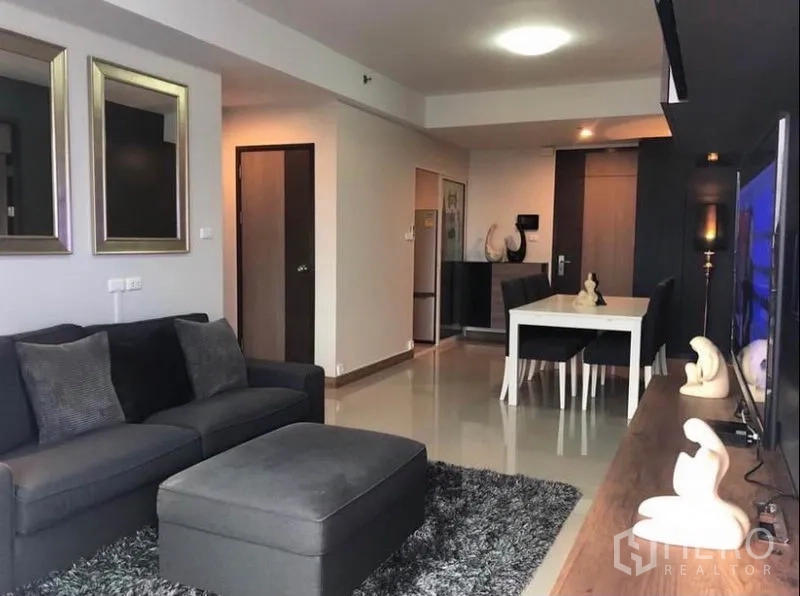 คอนโด ให้เช่าในBangkok - มุมมองจากห้องนั่งเล่นไปยังมุมทานอาหารและทางเข้า มีชั้นวางทีวีบิลท์อินสมัยใหม่