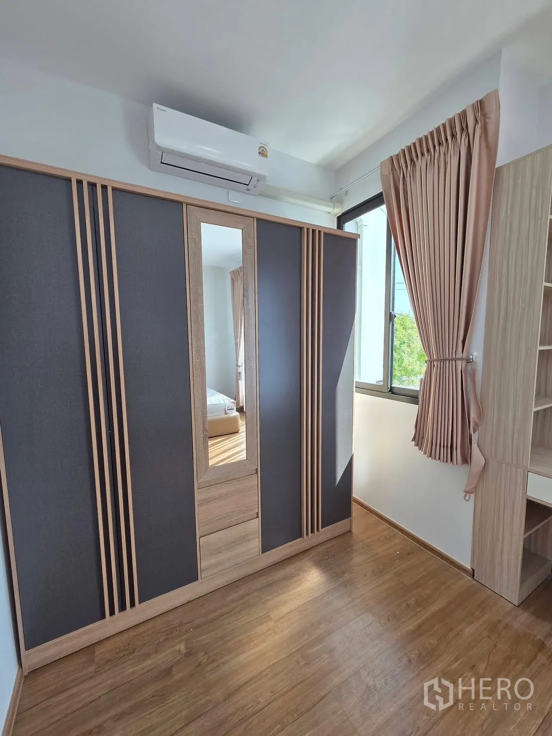 Townhouse for rent in Bang Phli, Samut Prakan - Secondary bedroom with large wardrobe, desk shelving, and window with curtains.