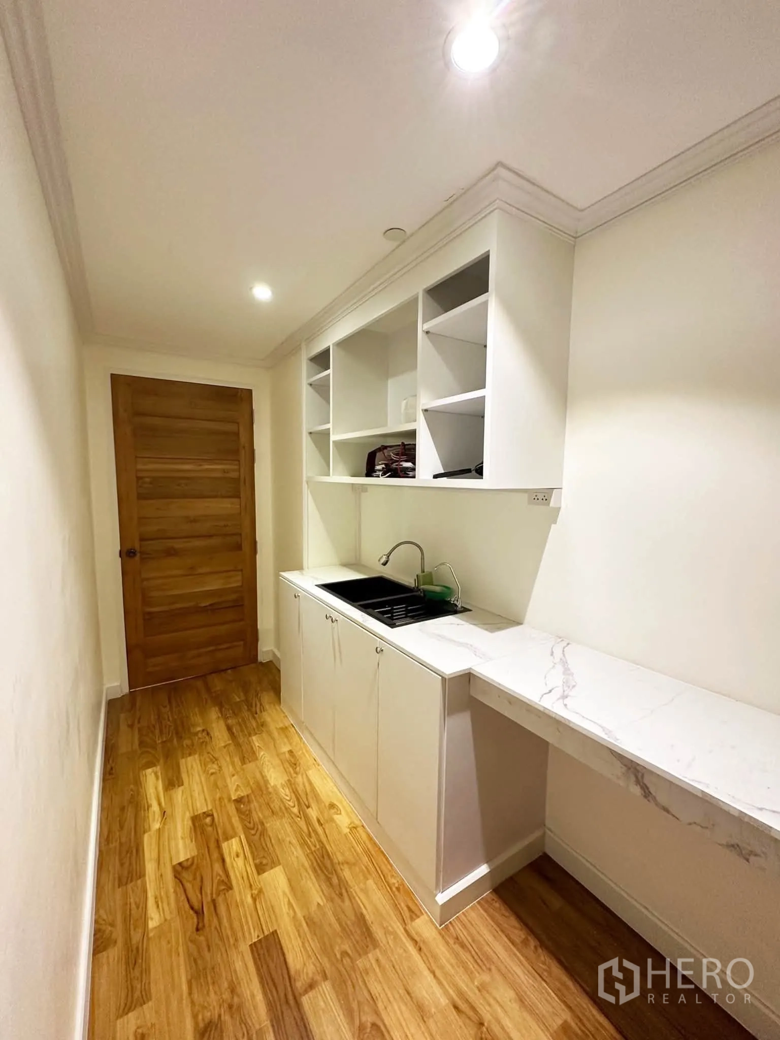 Condominium for sale in Khlong San, Bangkok - Compact pantry with sink, cabinetry, and a long marble counter.