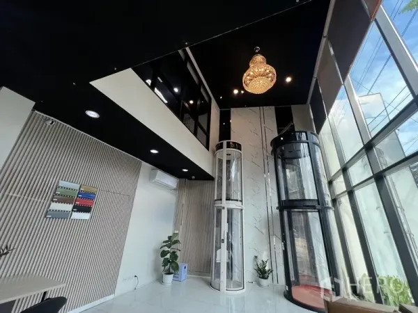 带办公室的家 出租在Phra Khanong, Bangkok - 挑高展厅空间，水晶吊灯与圆筒形玻璃电梯展示。