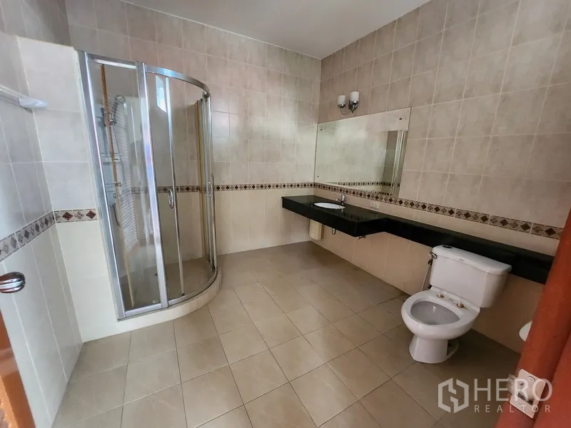 独立式住宅 出租在Prawet, Bangkok - 全瓷砖卫浴，玻璃淋浴房、超长台盆与坐便器。