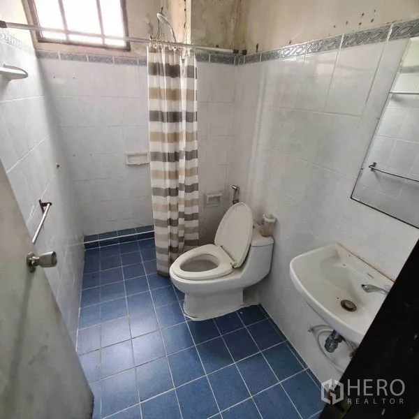 办公空间 出租在Yan Nawa, Bangkok - 卫生间，蓝色地砖、坐便、洗手盆与条纹浴帘淋浴。