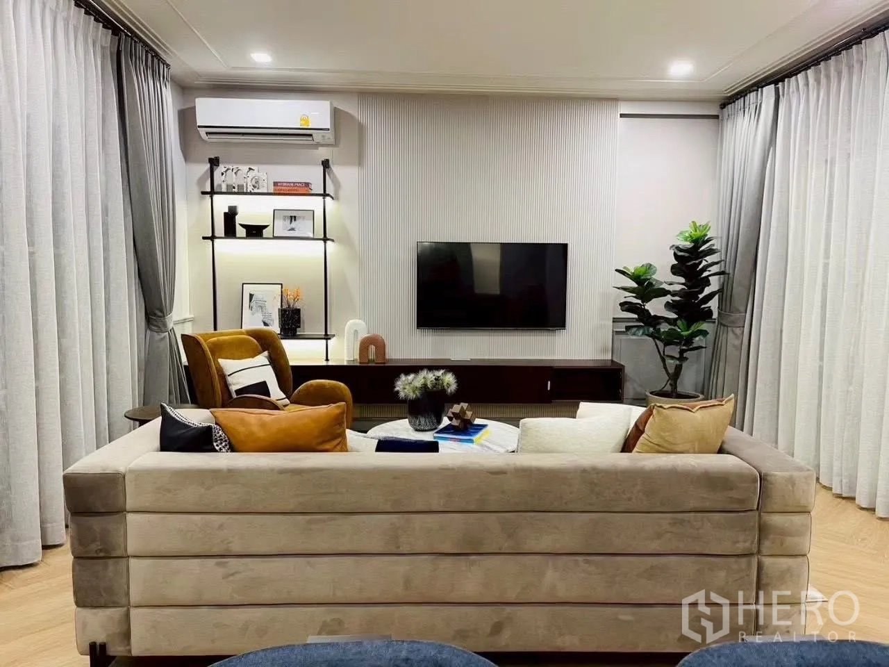 Detached House for rent in Bang Phli, Samut Prakan - Living area with wall-mounted TV, shelves, and air conditioner.