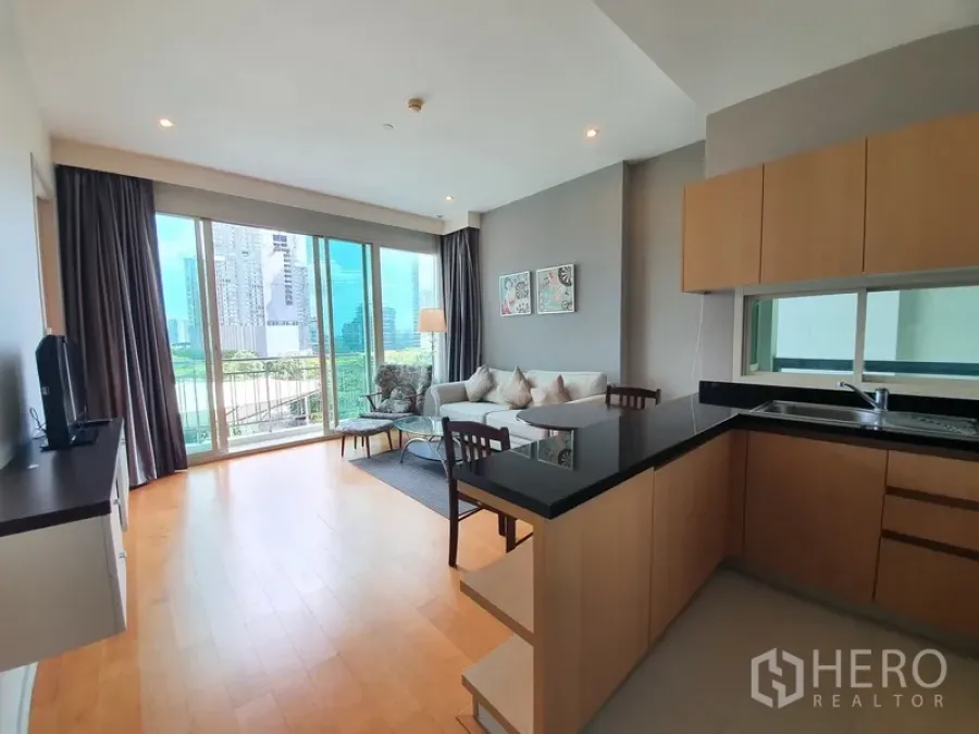 คอนโด ให้เช่าในChatuchak, Bangkok - พื้นที่โอเพ่นแพลนพร้อมครัวรูปตัว U ท็อปสีดำ และหน้าต่างบานใหญ่เห็นวิวเมืองและสวน