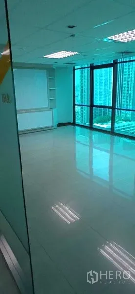 Office Space for rent in Huai Khwang, Bangkok - Corner office with floor-to-ceiling windows, city views, and glossy tile flooring.