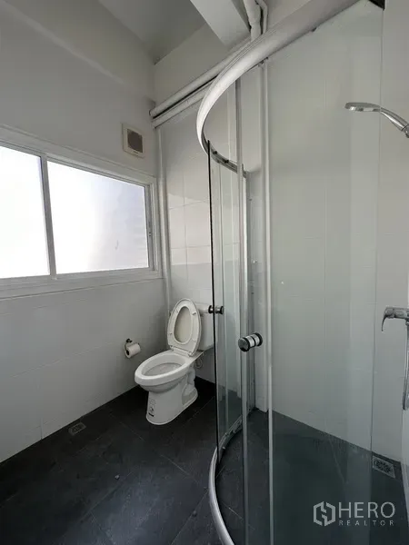 พื้นที่ขายปลีก ให้เช่าในWatthana, Bangkok - ห้องน้ำสะอาดพร้อมตู้อาบน้ำกระจกโค้ง โถสุขภัณฑ์ และหน้าต่างฝ้า.