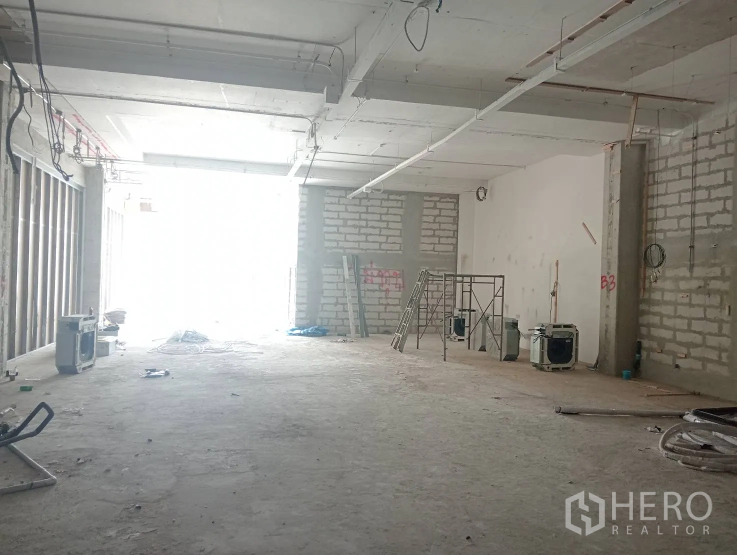 零售空间 出租 - 进深空间，入口自然采光，带脚手架与梯子。