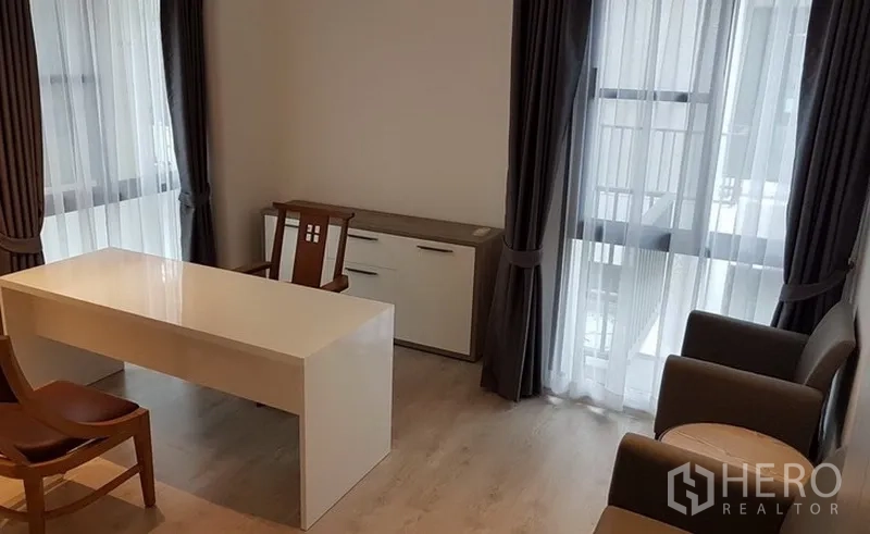 独立式住宅 出租在Prawet, Bangkok - 家用办公室，白色书桌、会客椅与落地窗帘。