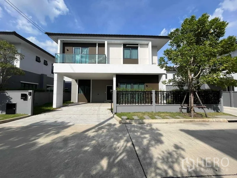 Detached House for rent in Don Mueang, Bangkok - Another front elevation view highlighting driveway, fenced yard and balcony.
