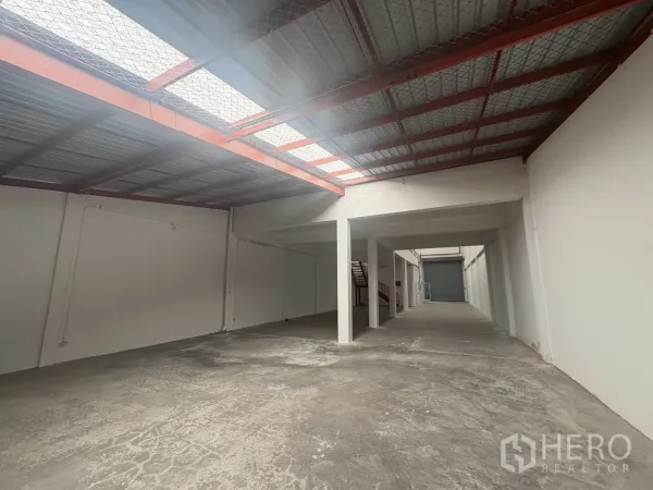 工厂 出租在Phra Samut Chedi, Samut Prakan - 狭长仓库通道，屋顶采光、柱体支撑，尽端设卷闸门。