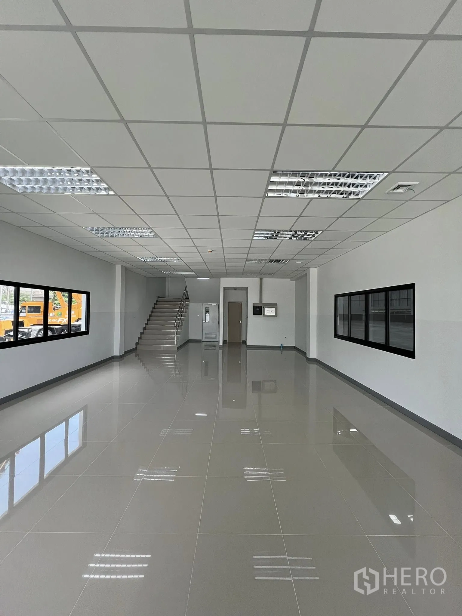 Warehouse for rent in Phra Pradaeng, Samut Prakan - Bright ground-floor office space with tiled flooring, drop ceiling lights and a staircase.