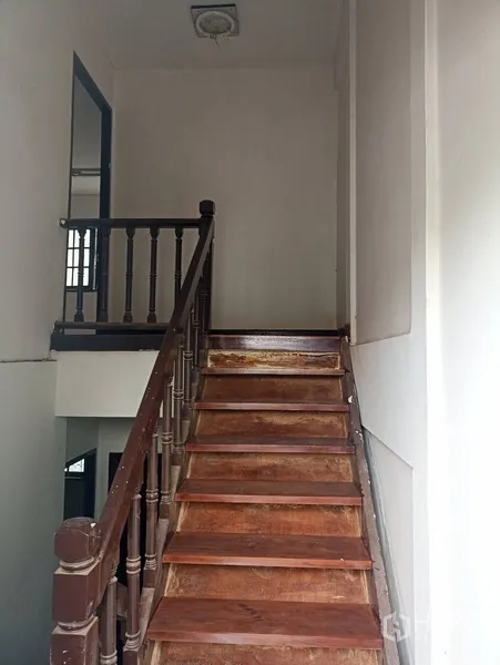 联排别墅 出租或出售在Wang Thonglang, Bangkok - 楼梯平台，木台阶、扶手与白色墙面。