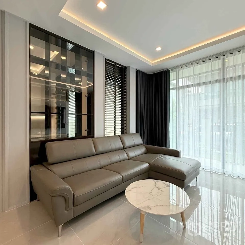 Detached House for rent in Bang Phli, Samut Prakan - Living room with L-shaped leather sofa and round marble coffee table.