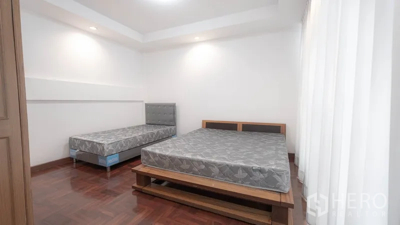 ทาวน์เฮาส์ ให้เช่าในWatthana, Bangkok - ห้องนอนแขกพื้นไม้พร้อมเตียงสองหลัง